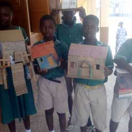 SchülerInnen der Partnerschule in Eikwe mit selbstgebauten Häusern